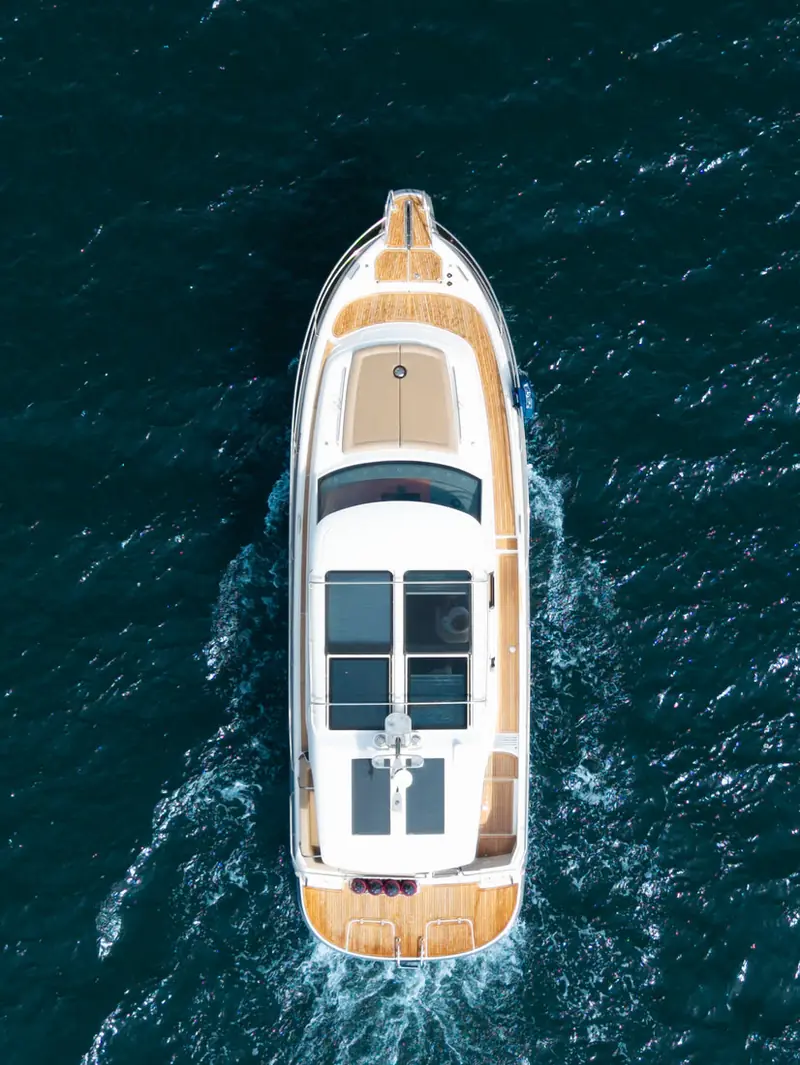 A Nimbus 365 cruising across dark water, seen from above